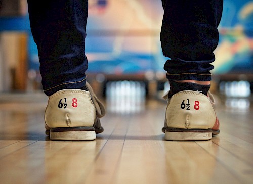 Alten Bowlingschuhen im Hintergrund verschwommen eine Bowlingbahn