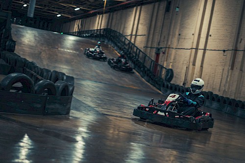 Kart Fahrer auf einer Indoor Strecke mit Gefälle